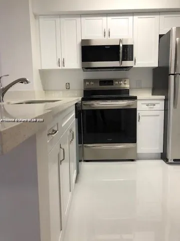 a kitchen with stainless steel appliances a stove a microwave and a refrigerator