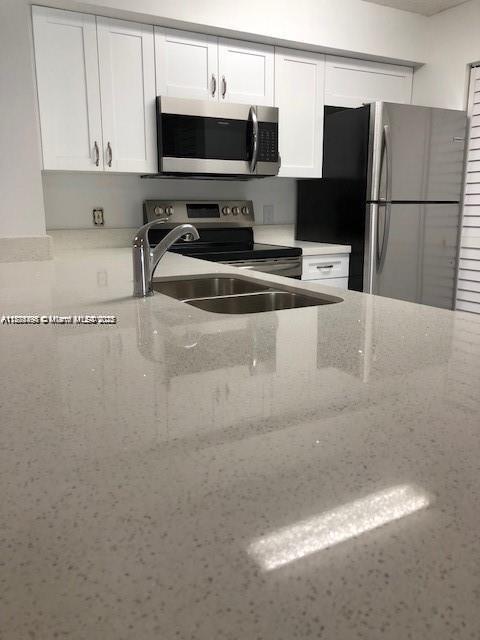 650 South Park Road, Unit 285 Hollywood, FL 33021 - Photo 2 of 13 a kitchen with stainless steel appliances a refrigerator a sink a stove and microwave