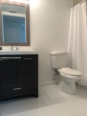 a bathroom with a toilet a sink and mirror