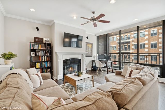 a living room with furniture large window and a fireplace