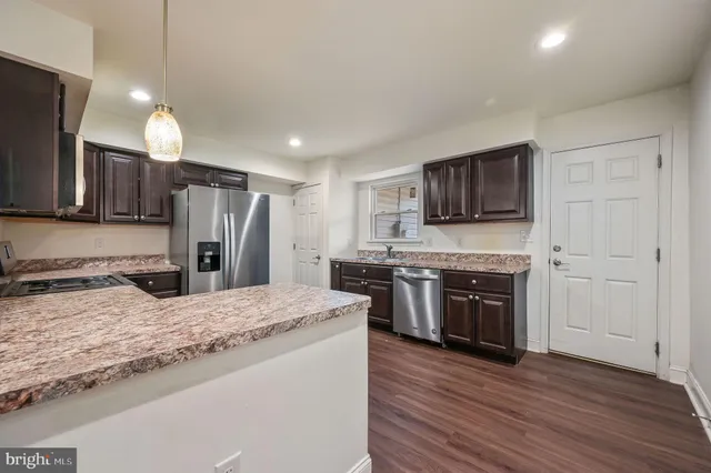 a kitchen with stainless steel appliances granite countertop a refrigerator stove microwave and sink