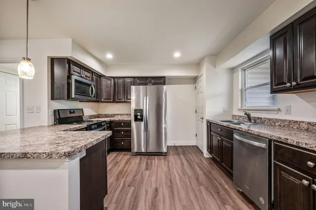 a kitchen with granite countertop stainless steel appliances cabinets a sink and a counter space