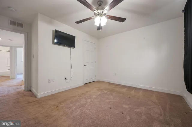 an empty room with fan and windows