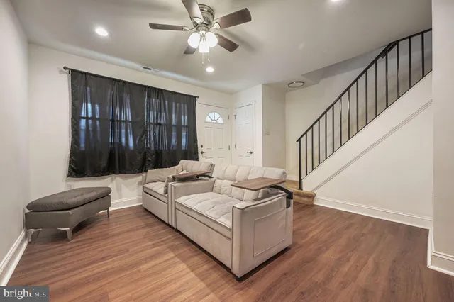 a living room with furniture and a wooden floor