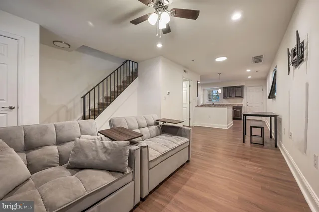 a living room with furniture and a wooden floor