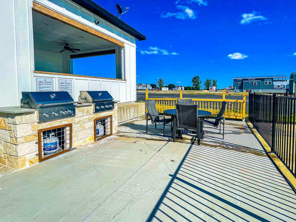 Lot 199 Peninsula Road Kerens, TX 75144 - Photo 21 of 26 a view of a patio with table and chairs with wooden floor and fence