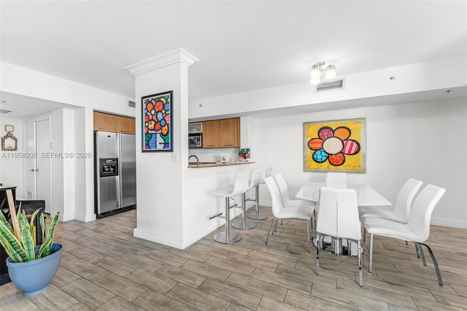 9066 Southwest 73rd Court, Unit 908 Miami, FL 33156 - Photo 6 of 46 a living room with furniture a refrigerator and a dining table