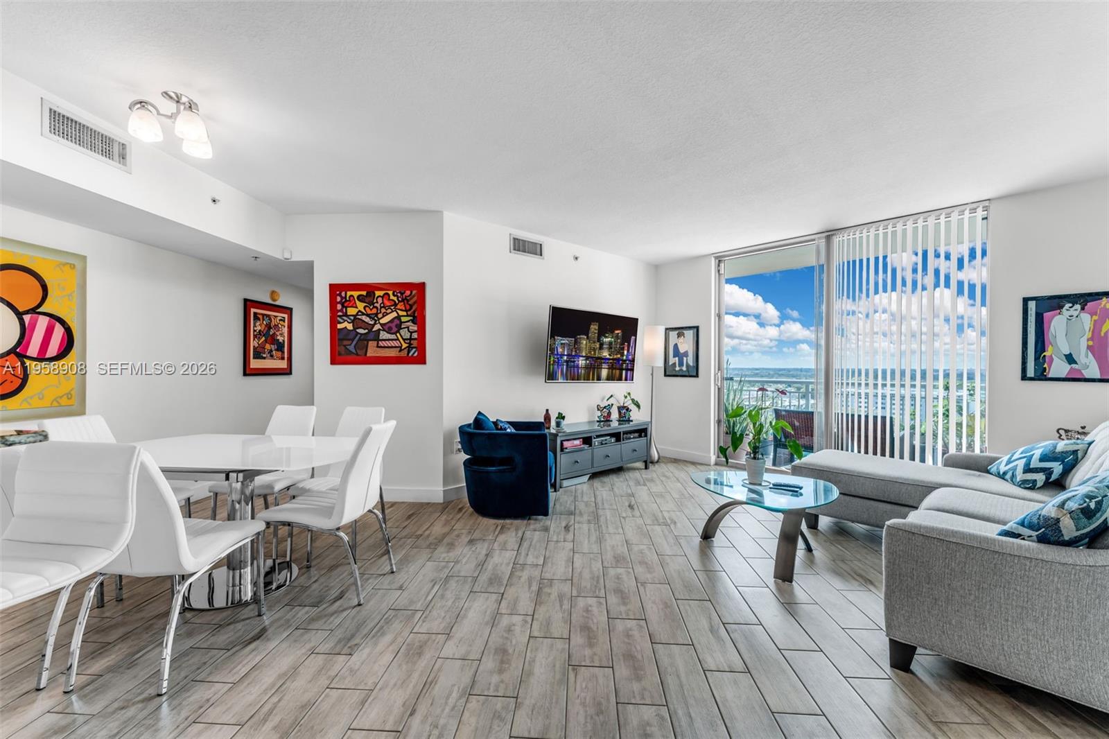 9066 Southwest 73rd Court, Unit 908 Miami, FL 33156 - Photo 7 of 46 a living room with furniture a flat screen tv and a large window