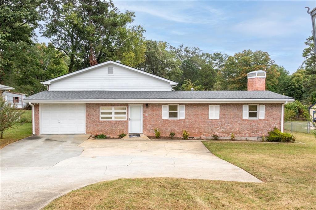 a front view of a house with a yard and trees