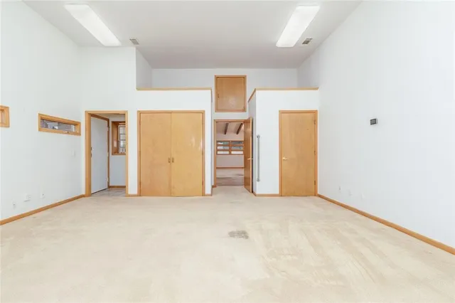 an empty room with closet and mirrors