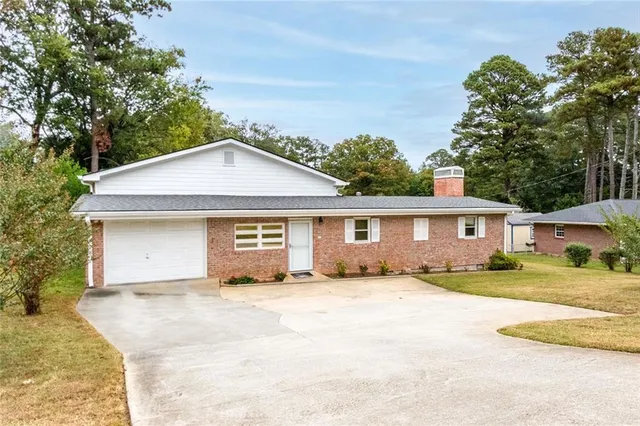a front view of a house with yard and tree s