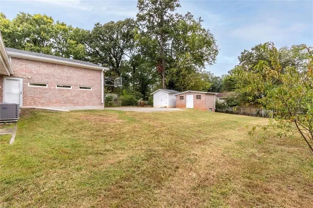 a front view of house with yard and trees in the background