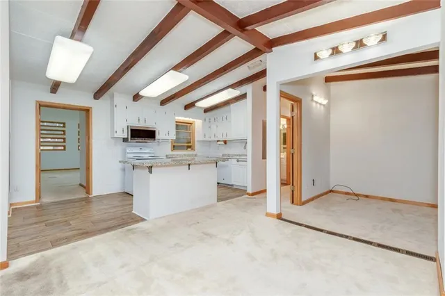 a view of kitchen with granite countertop cabinets and white appliances