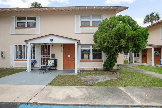 a front view of a house with a yard and trees