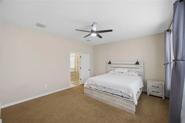 a bedroom with a bed and a ceiling fan