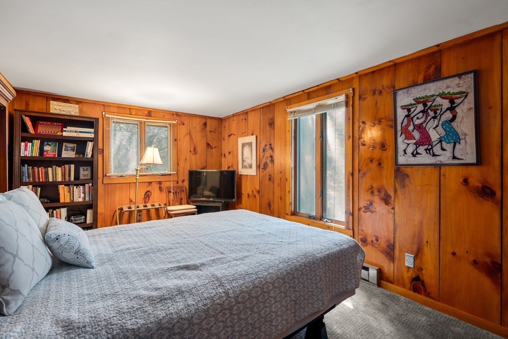 44 Mashapaug Road Holland, MA 01521 - Photo 40 of 41 a bedroom with a large bed and a book shelf