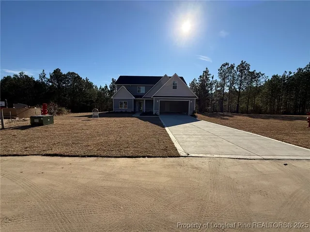 a front view of a house with a yard and trees