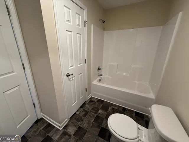a bathroom with a toilet and a shower