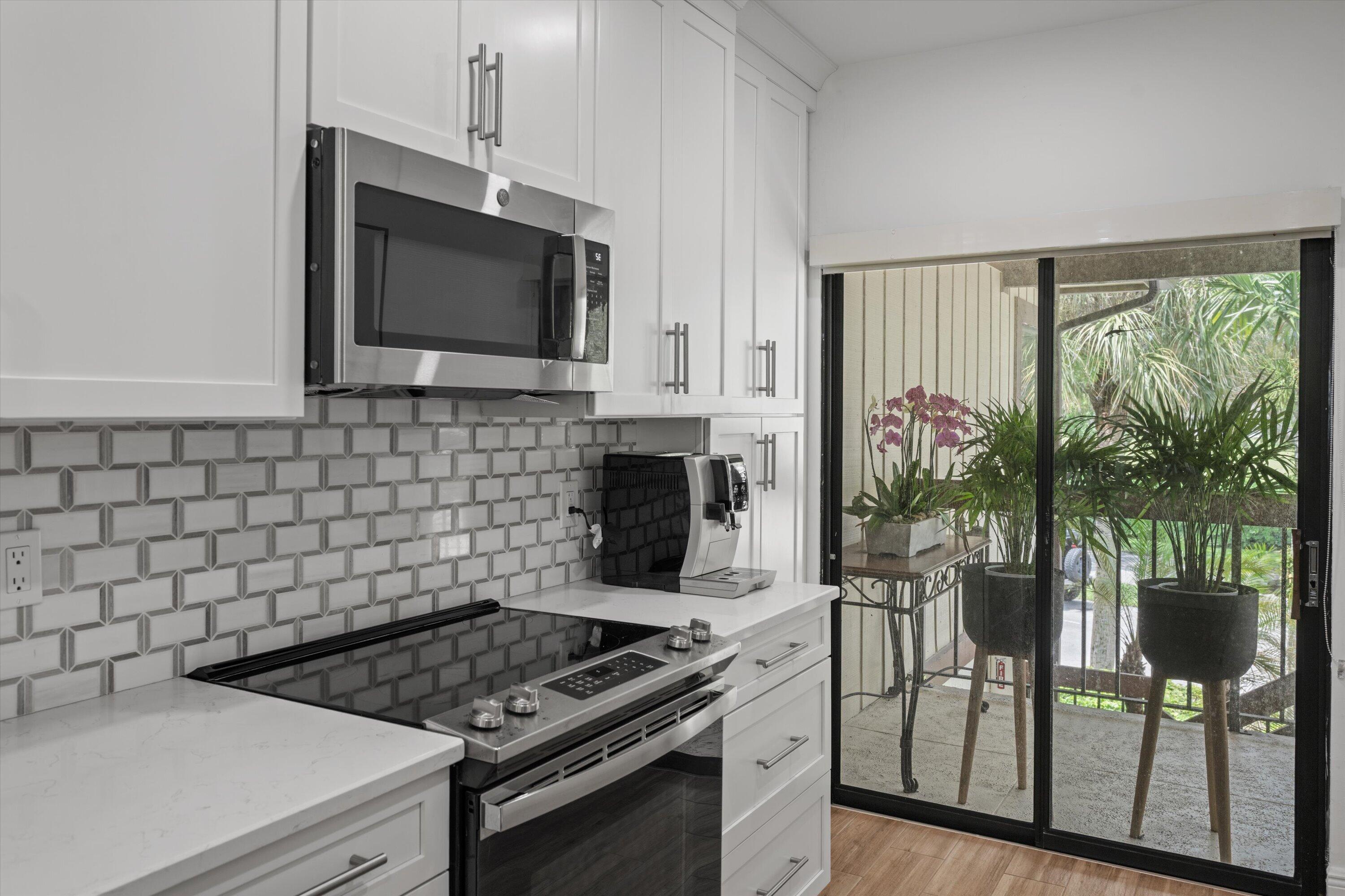 13400 Polo Road West, Unit 203 Wellington, FL 33414 - Photo 12 of 26 a kitchen with a stove a sink and a microwave