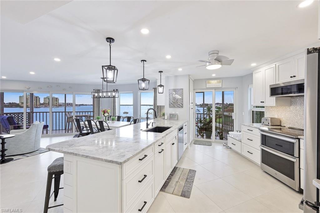a large kitchen with stainless steel appliances kitchen island granite countertop a large center island and a stove top oven