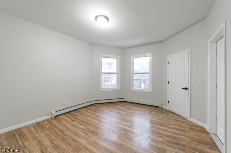 874 South 16th Street Newark, NJ 07108 - Photo 12 of 22 a view of an empty room with wooden floor and a window