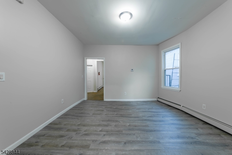 874 South 16th Street Newark, NJ 07108 - Photo 17 of 22 a view of an empty room with wooden floor and a window
