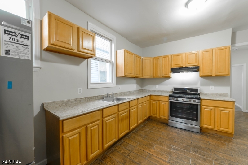 874 South 16th Street Newark, NJ 07108 - Photo 4 of 22 a kitchen with stainless steel appliances granite countertop a stove a sink and a microwave
