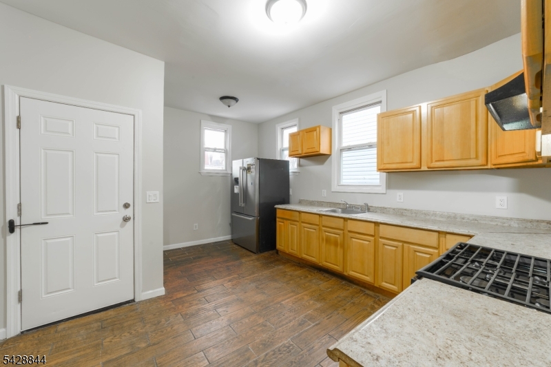 874 South 16th Street Newark, NJ 07108 - Photo 5 of 22 a kitchen with stainless steel appliances granite countertop a stove a sink and a refrigerator
