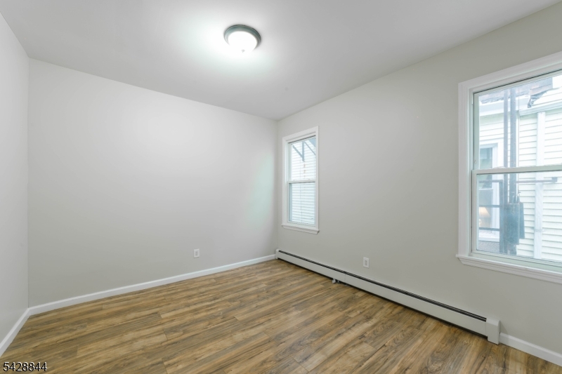 874 South 16th Street Newark, NJ 07108 - Photo 7 of 22 an empty room with wooden floor and windows