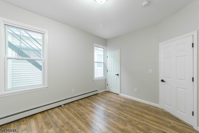 874 South 16th Street Newark, NJ 07108 - Photo 8 of 22 a view of an empty room with wooden floor and a window