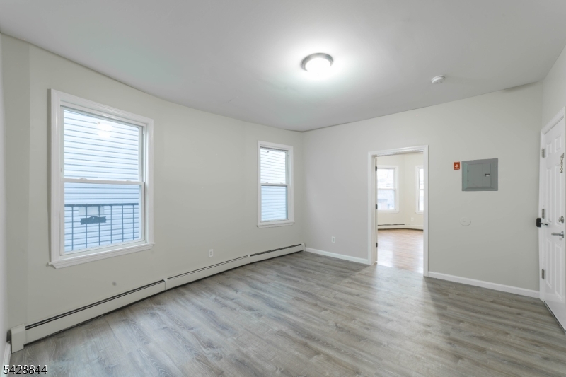 874 South 16th Street Newark, NJ 07108 - Photo 9 of 22 an empty room with wooden floor and windows