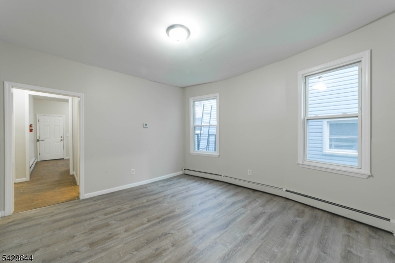874 South 16th Street Newark, NJ 07108 - Photo 10 of 22 a view of an empty room with wooden floor and a window
