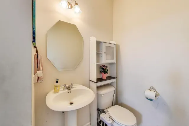 a bathroom with a sink mirror and toilet