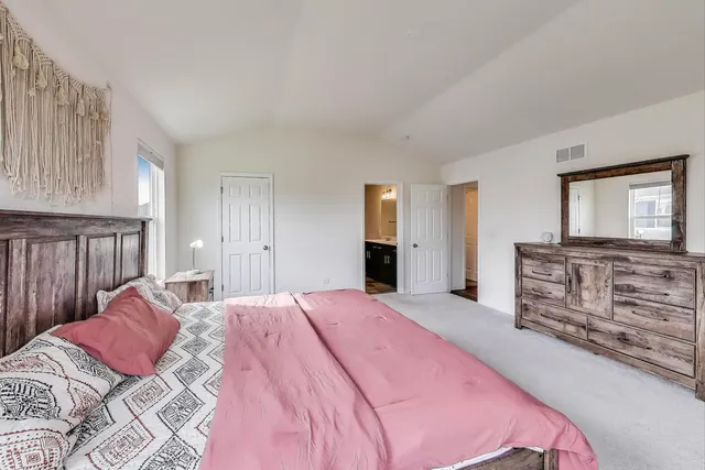 a bedroom with a large bed and a dresser