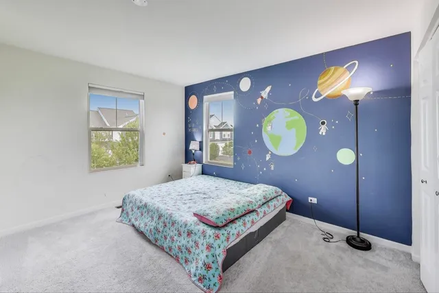 a bedroom with a bed and painting on the wall