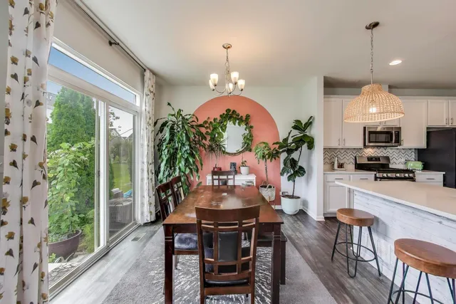 a view of a dining room with furniture a chandelier and wooden floor