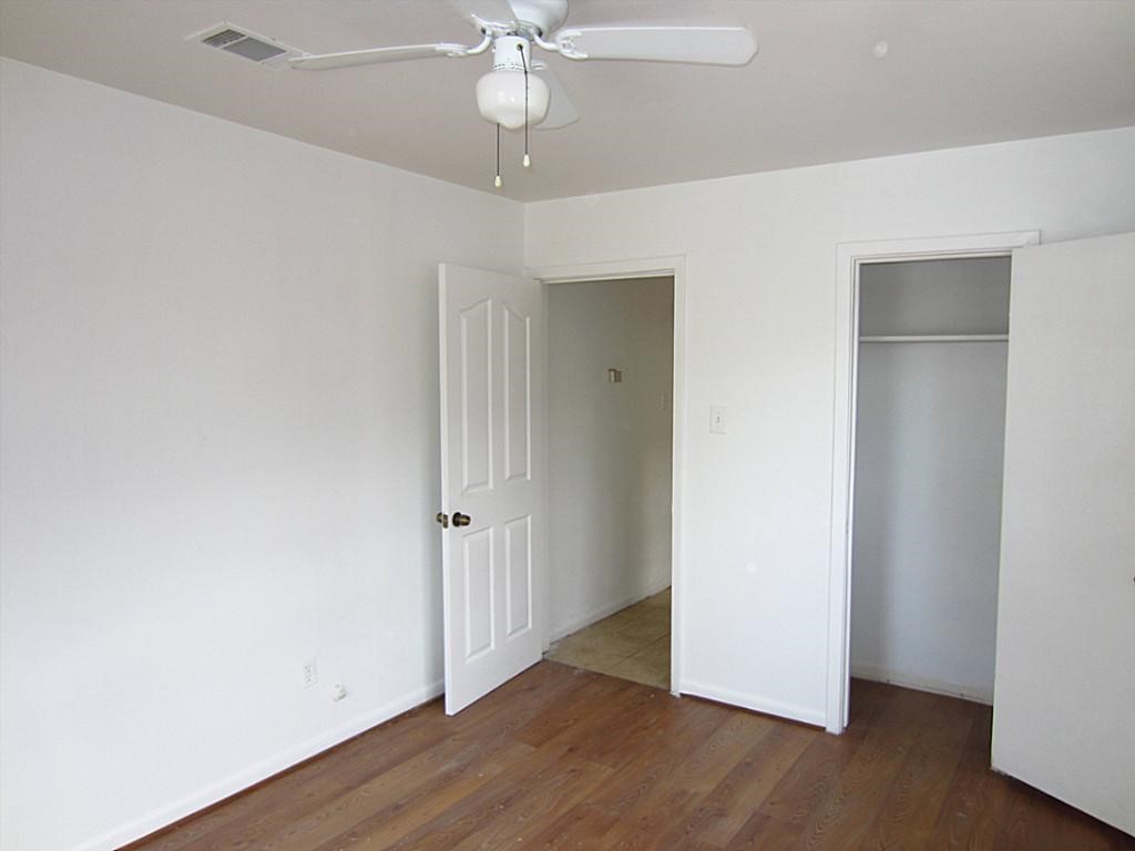 3810 Cochran Street Houston, TX 77009 - Photo 8 of 12 an empty room with wooden floor fan and windows