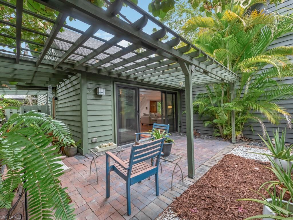 1271 Solana Road, Unit E4 Naples, FL 34103 - Photo 18 of 21 a backyard of a house with outdoor seating