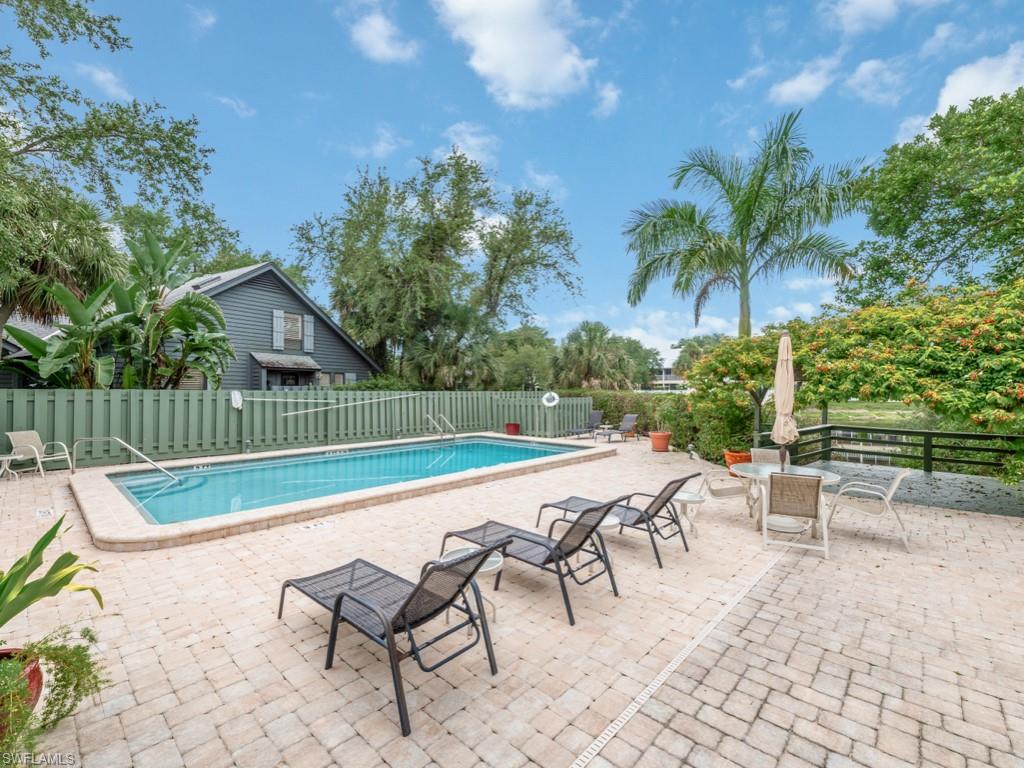 1271 Solana Road, Unit E4 Naples, FL 34103 - Photo 20 of 21 a view of a swimming pool with a lounge chair and a fire pit