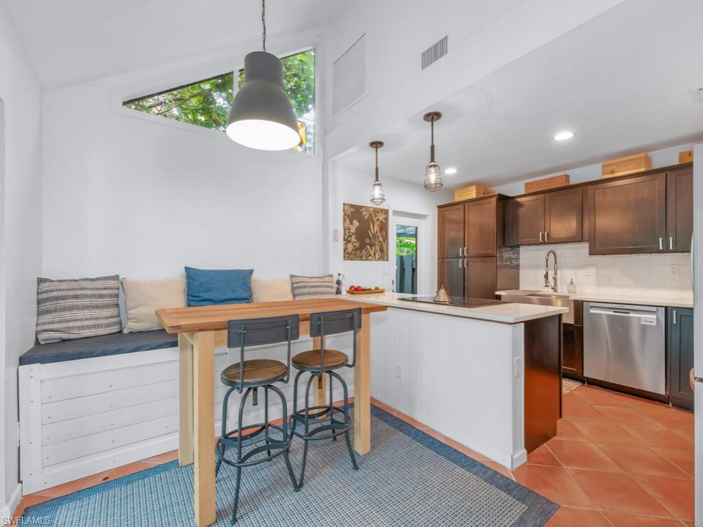 1271 Solana Road, Unit E4 Naples, FL 34103 - Photo 3 of 21 a kitchen with stainless steel appliances granite countertop a sink a stove a refrigerator cabinets and chairs