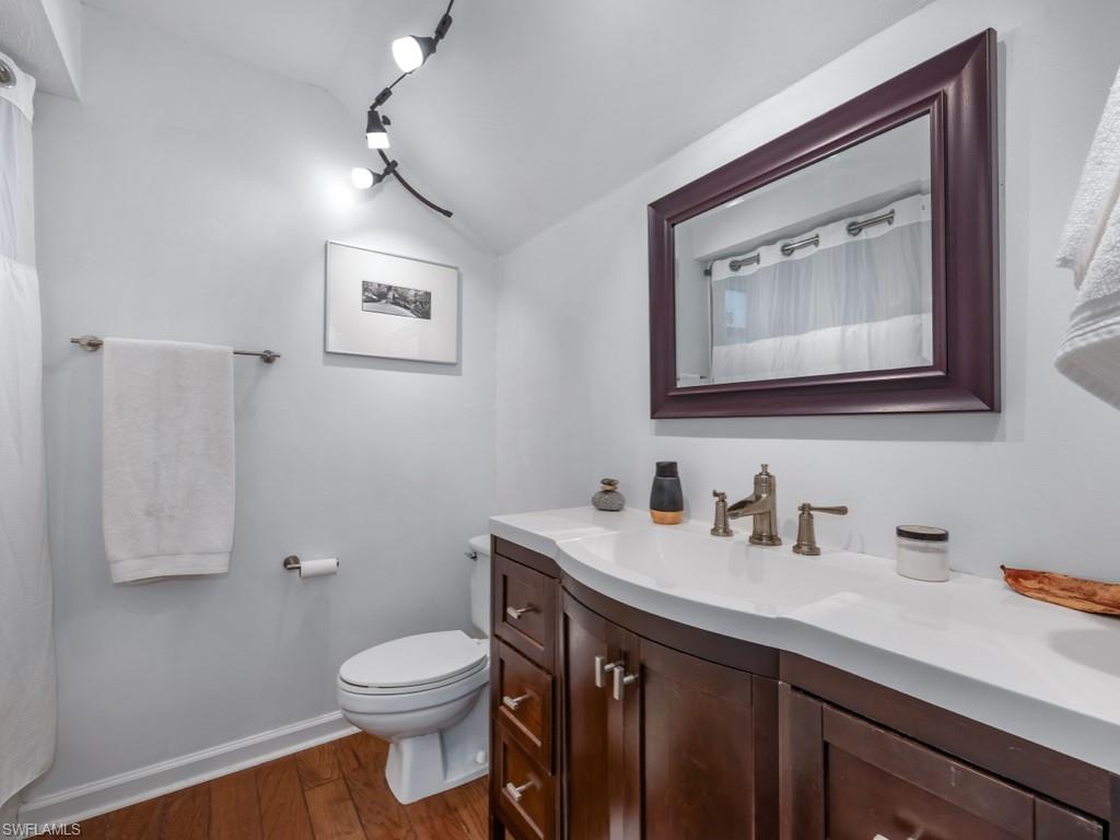1271 Solana Road, Unit E4 Naples, FL 34103 - Photo 10 of 21 a bathroom with a toilet a sink and mirror