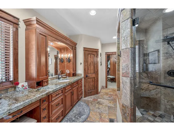 a bathroom with a granite countertop sink mirror and a shower