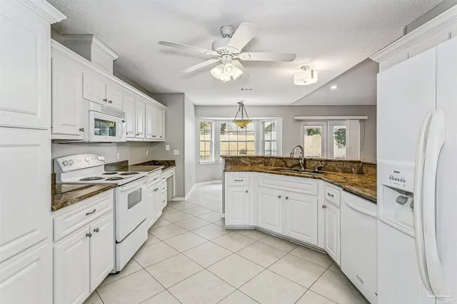 a large white kitchen with cabinets