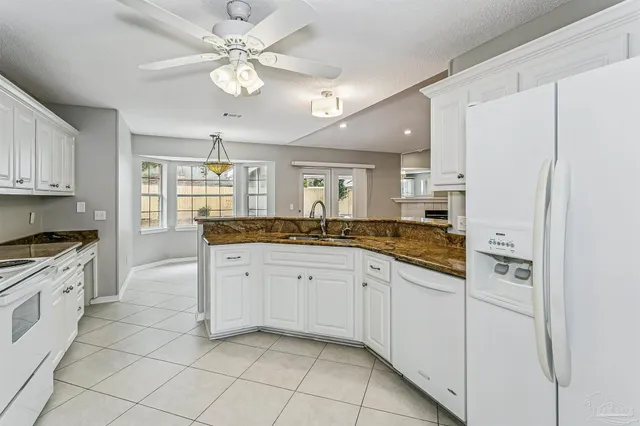 a large white kitchen with a refrigerator a sink dishwasher and a stove