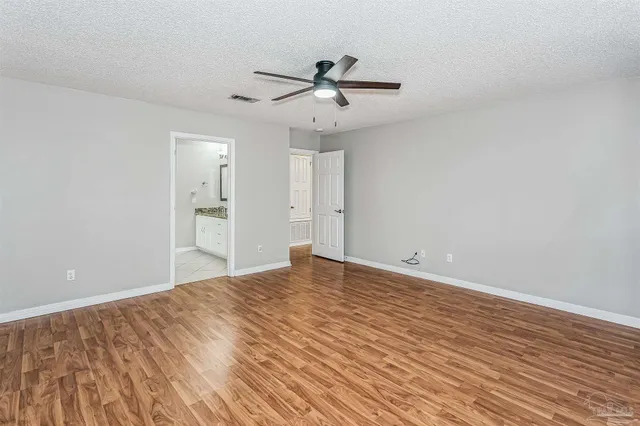 a view of empty room with wooden floor and ceiling fan