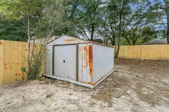 a view of a yard with a house and a large tree