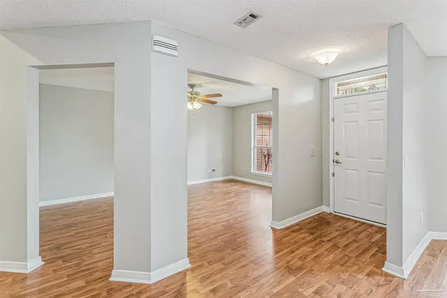 a view of empty room with wooden floor