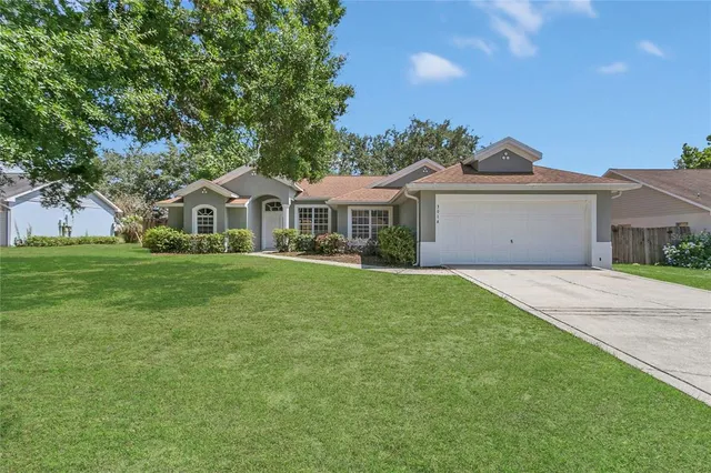 a front view of a house with a garden and yard