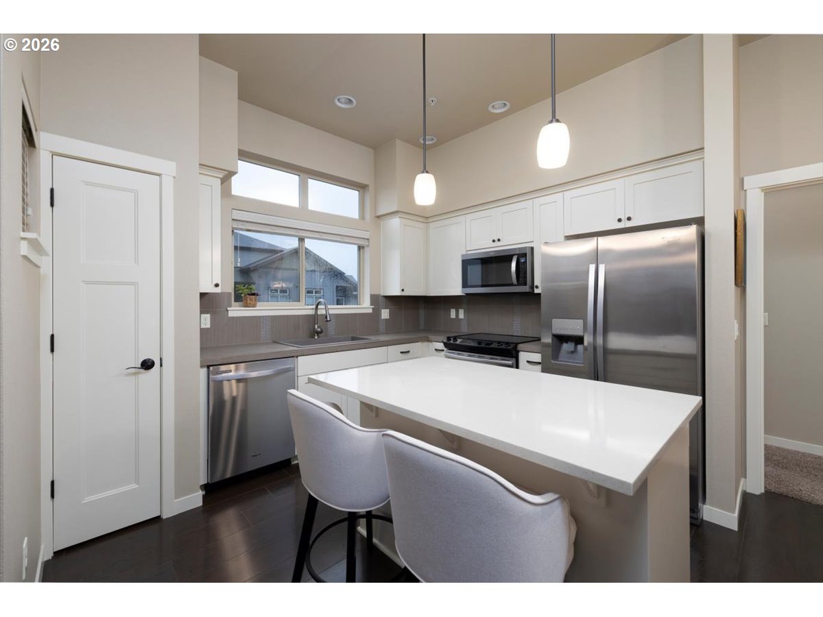 13895 Southwest Meridian Street, Unit 412 Beaverton, OR 97005 - Photo 11 of 38 a kitchen with kitchen island a counter top space appliances and cabinets