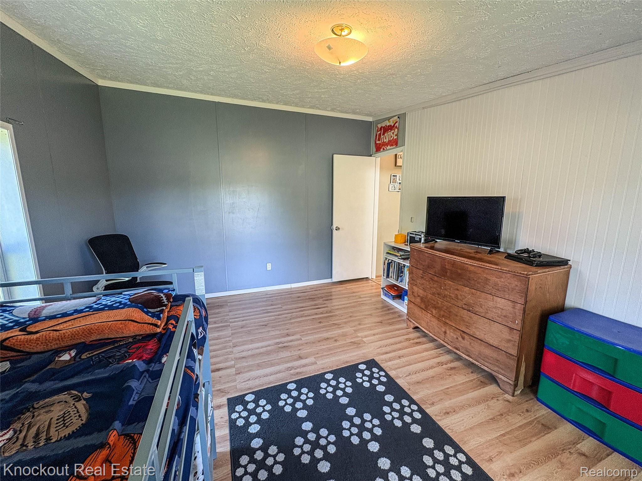 7760 Bell Road Birch Run, MI 48415 - Photo 47 of 68 Interior room featuring wood-finish flooring and two-tone wall paneling